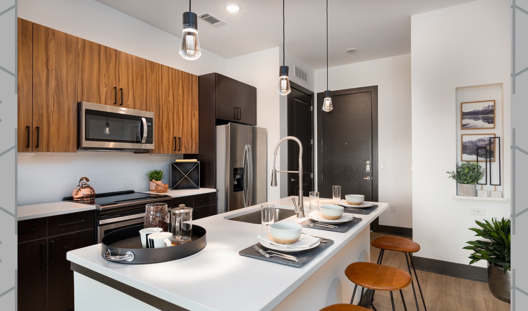 Chic Kitchen Interior with Island Stunning kitchen at tThe Keswick featuring wood-tone cabinetry and pendant lights